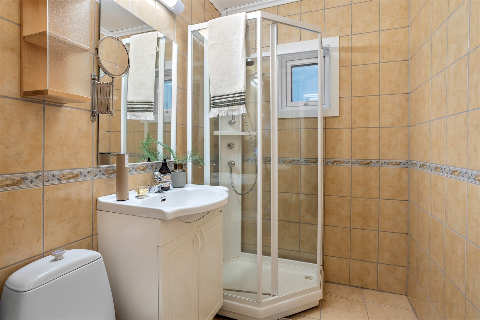 Badet har flislagt gulv med varmekabler, og er innredet med servantinnredning, dusjkabinett og wc. Rommet er renovert i 2001. Galleribilde