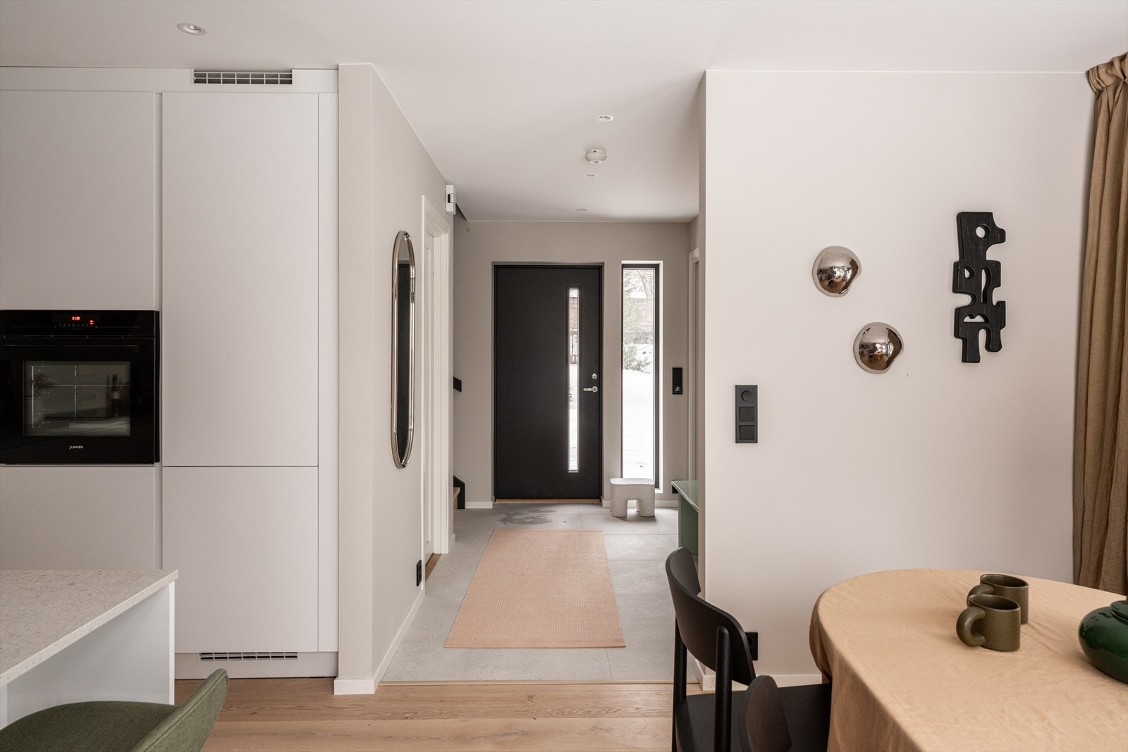 Bilder fra visningsbolig. Velkommen inn i en lys entré med lyse flater og mørke detaljer som setter tonen for boligen. Galleribilde