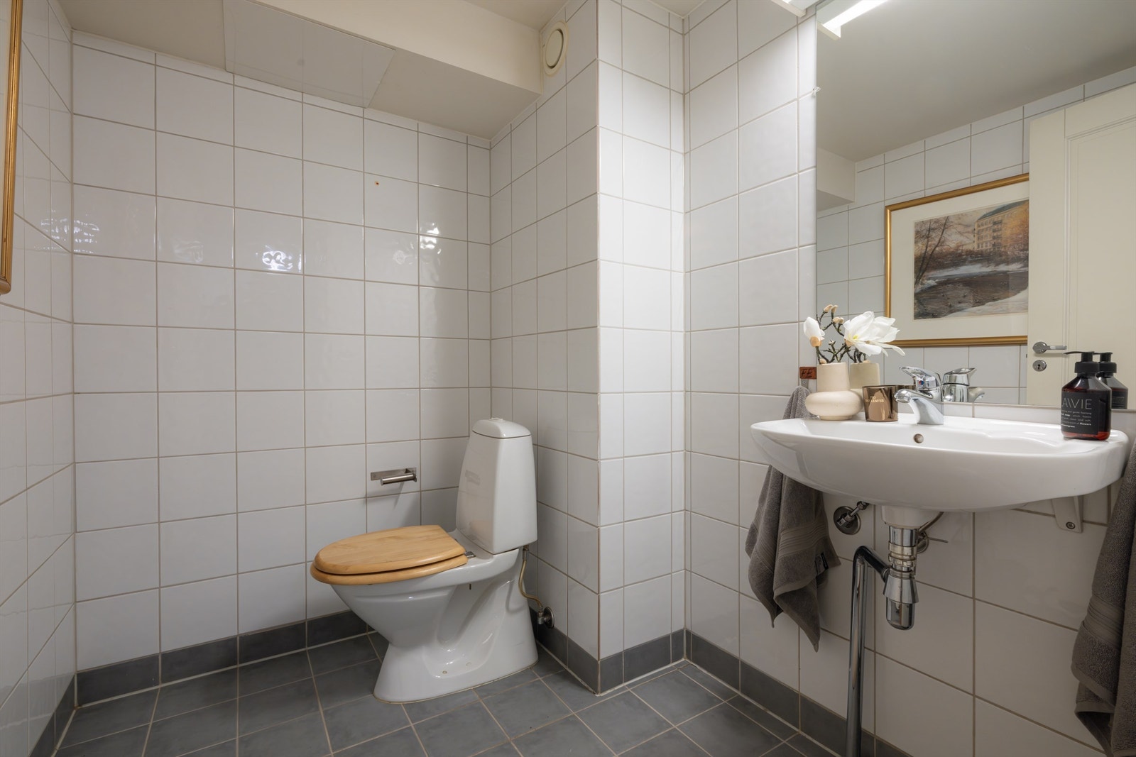 Praktisk og pent toalettrom fra ombyggingsårene 2001-2002. Rommet har flislagt gulv og flislagte vegger samt malt, slett himling. Galleribilde