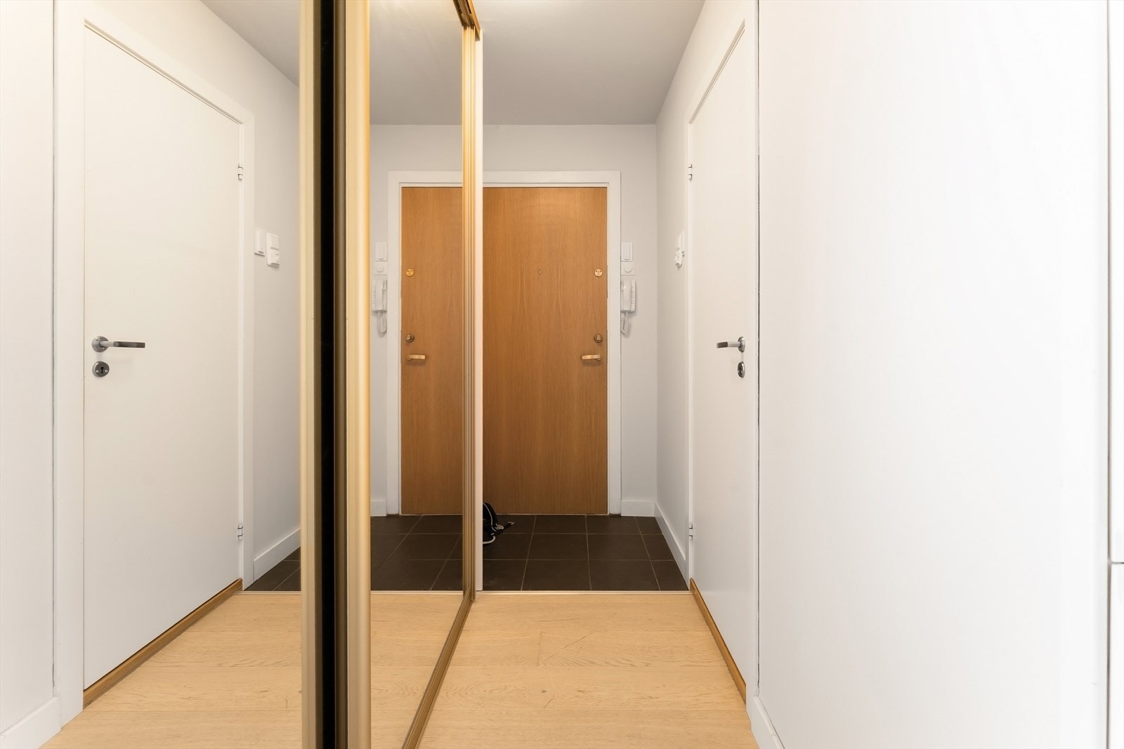 Velkommen inn til en hyggelig og lys entré med stor skyvedørsgarderobe Galleribilde