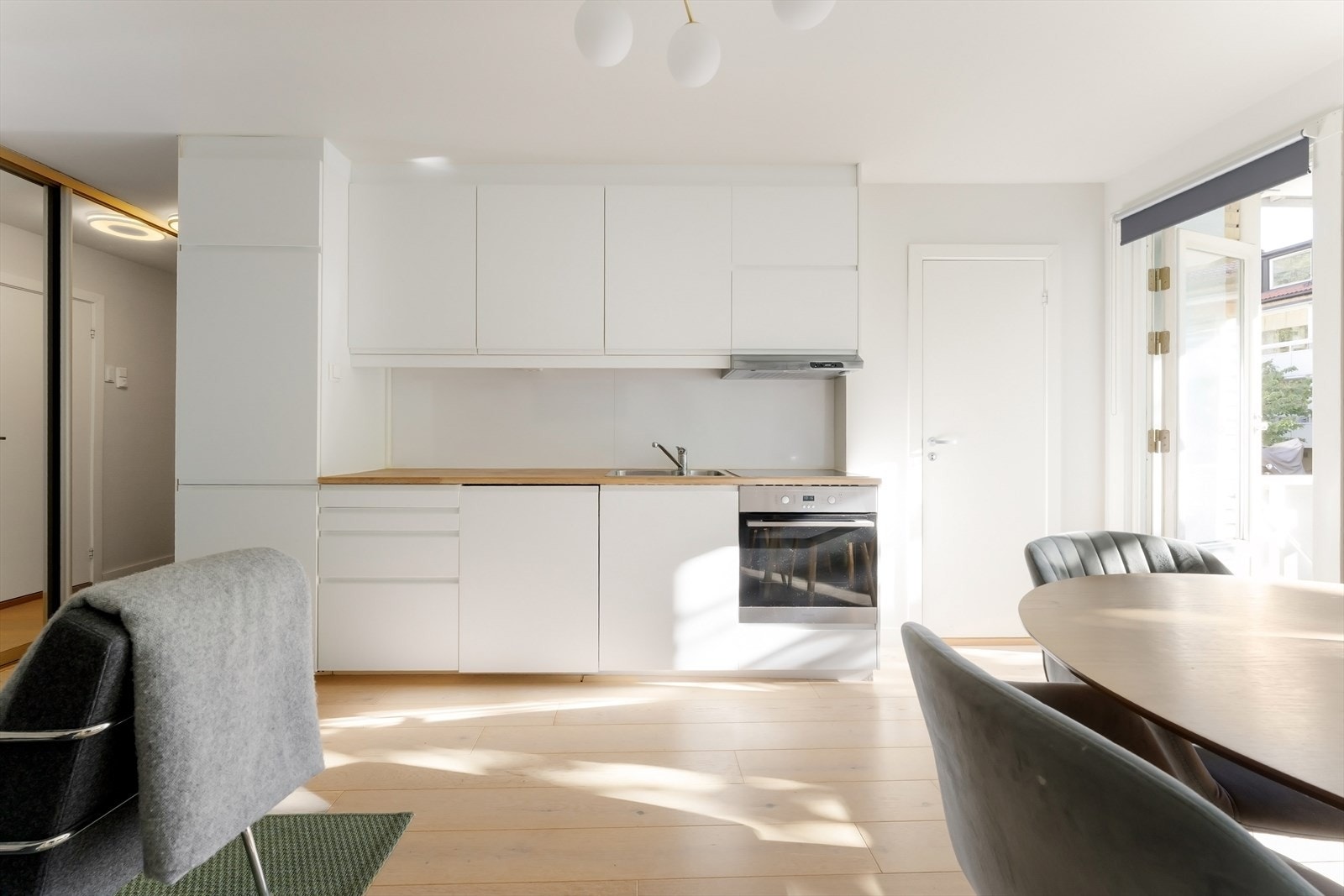 Kjøkkenet har et stilrent utrykk med innredning fra IKEA, heltre benkeplate og integrerte hvitevarer Galleribilde