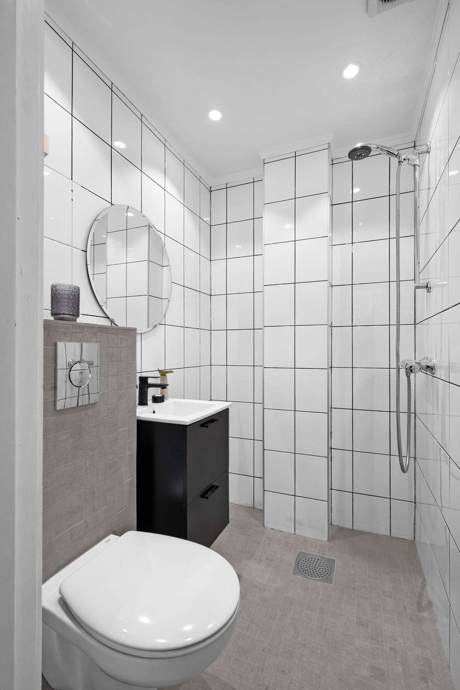 Flislagt baderom med toalett, baderomsinnredning og dusjhjørne Galleribilde