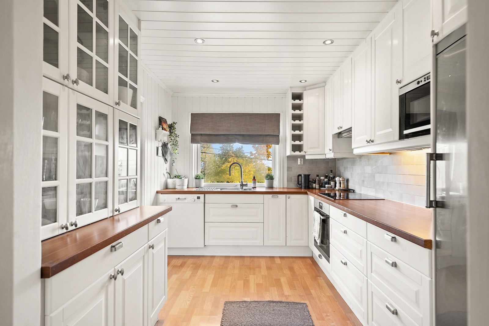 Flott kjøkken i hvit moderne utførsel og noen integrerte hvitevarer Galleribilde