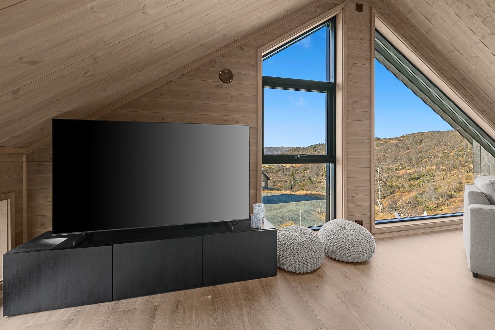 Sofakroken byr på både utsikt og komfort - perfekt for late kvelder foran TV-en eller rolige morgener med fjellene som bakteppe. Galleribilde