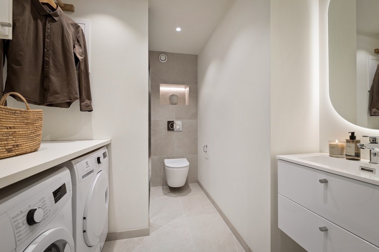 Romslig bad/vaskerom fra 2026 med flislagt gulv og gulvvarme Galleribilde