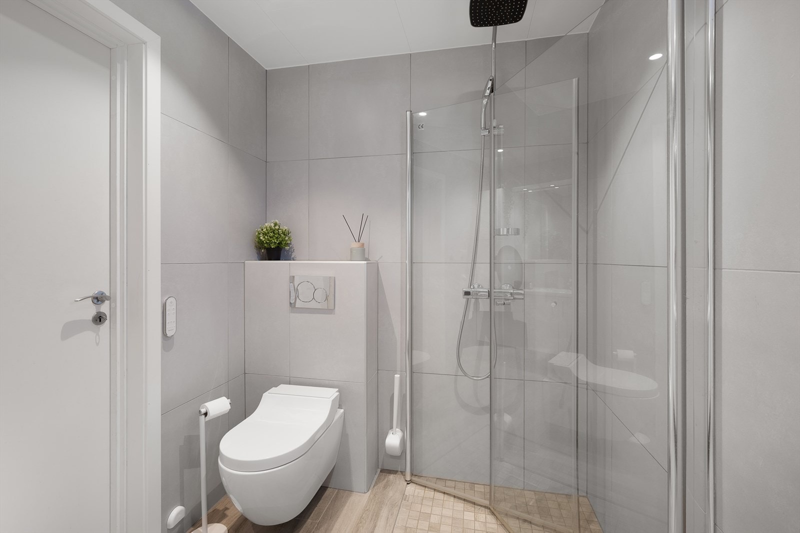 Badet er innredet med større baderomsinnredning, dusjtoalett fra Geberit (bidè) og innfellbare dusjdører av herdet glass. Dusjen har også regnfall og håndholdt dusjhodet. Galleribilde