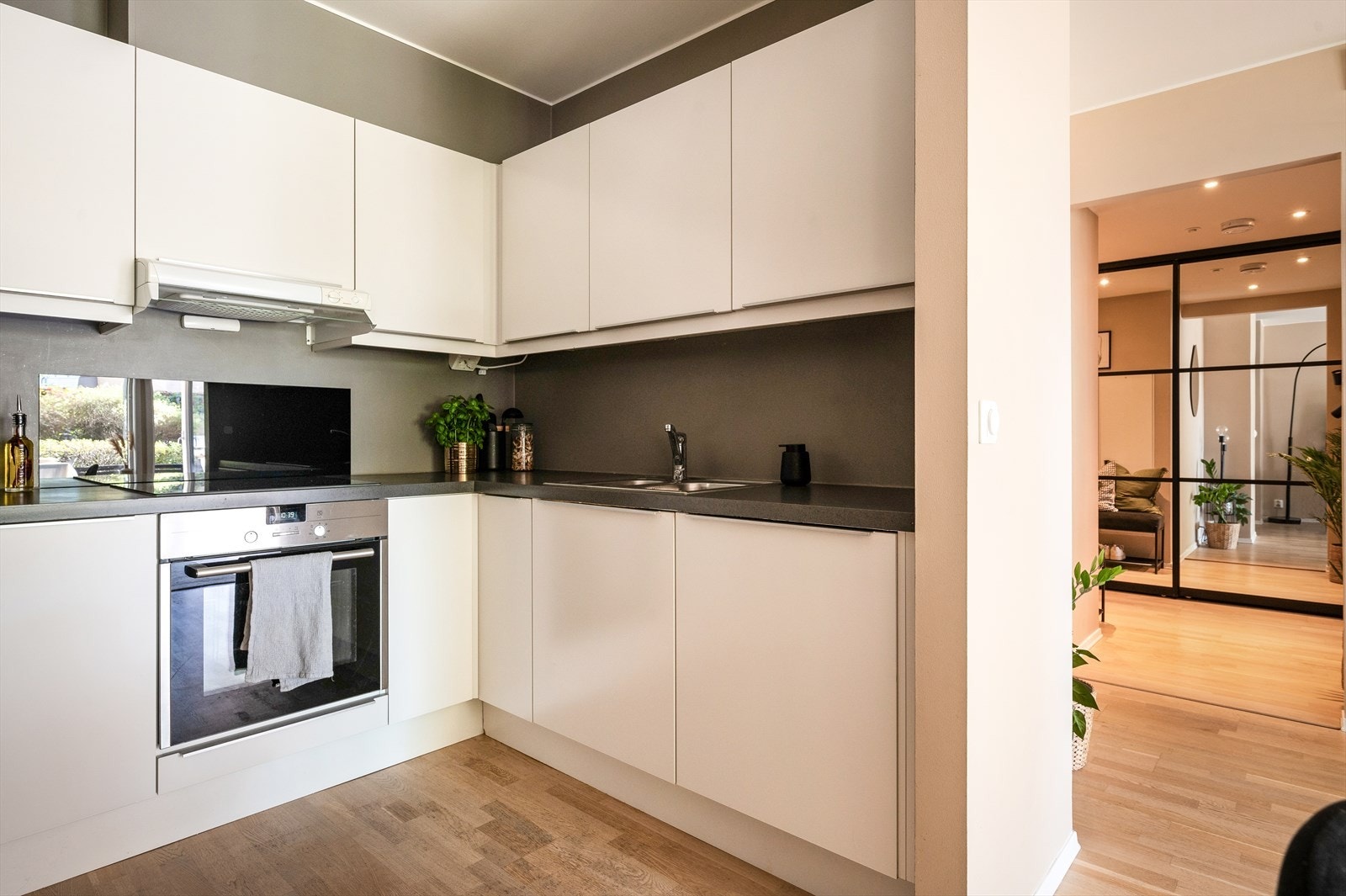 Innredning med glatte fronter, laminat benkeplate med nedfelt vask, og integrert platetopp, stekeovn og oppvaskmaskin. Avtrekk over kokeplass. Galleribilde