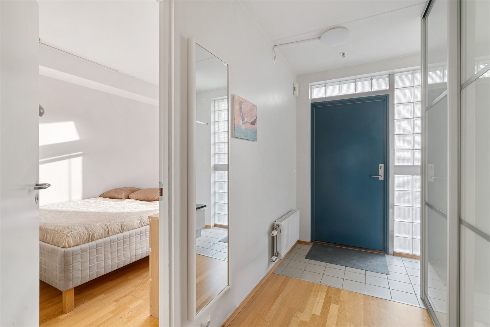 Lys og flislagt entré som gir et rettmessig førsteinntrykk av leiligheten. Her er det godt med avsatt plass til klesheng og oppbevaring i skyvedørsgarderobe. Galleribilde