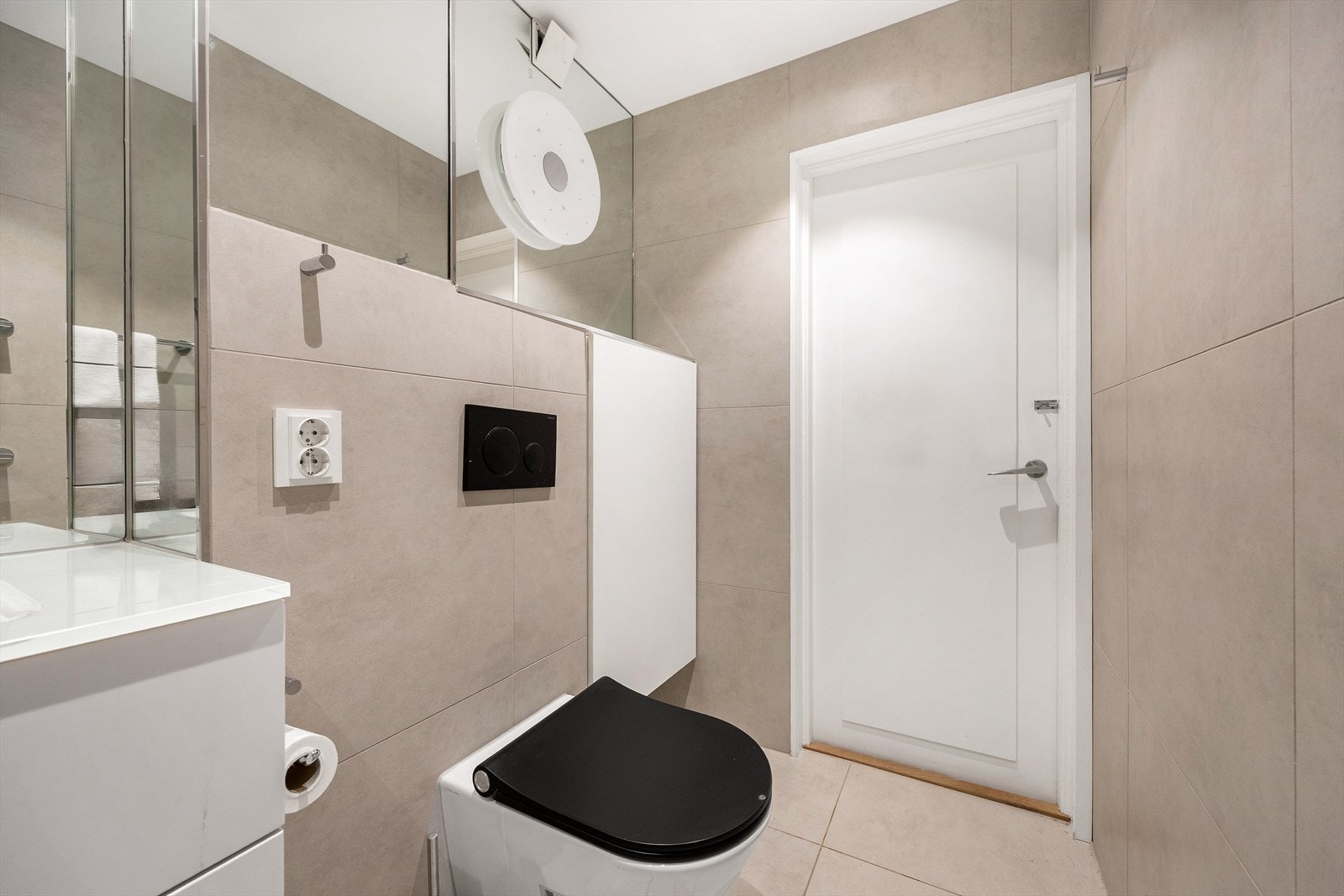 Badet har vegghengt toalett, speilskap og integrert oppbevaring for et ryddig uttrykk. Galleribilde