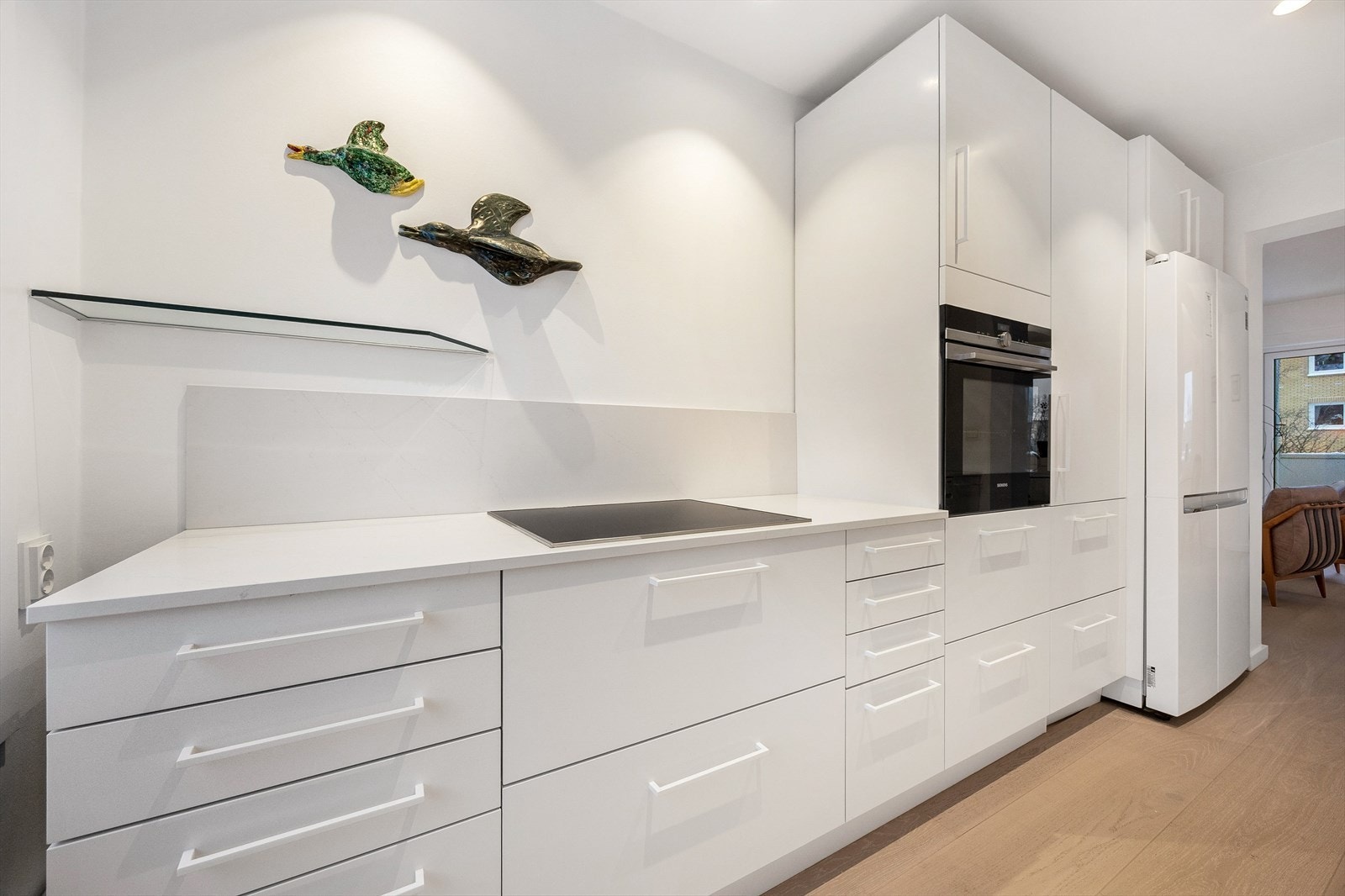 Moderne kjøkken fra 2021 med høyglansfronter, rikelig med skapplass og integrerte hvitevarer. Galleribilde