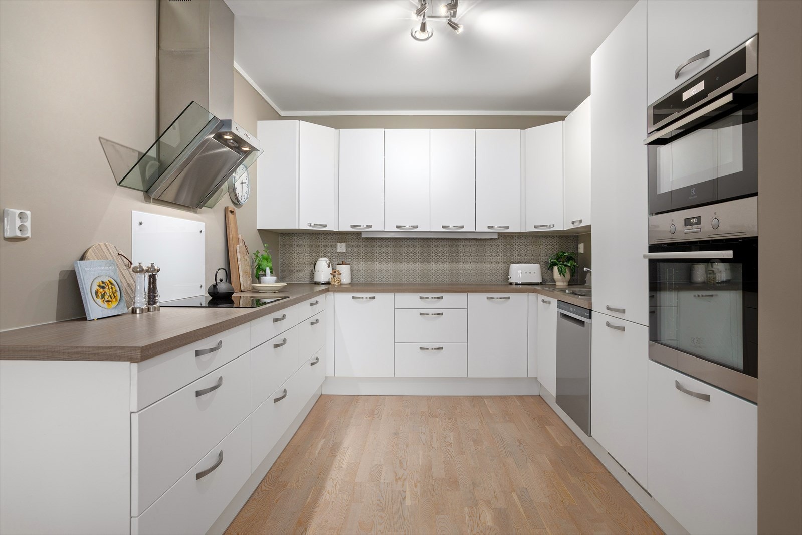 Pent kjøkken fra JKE Design med glatte fronter og benkeplate i laminat Galleribilde