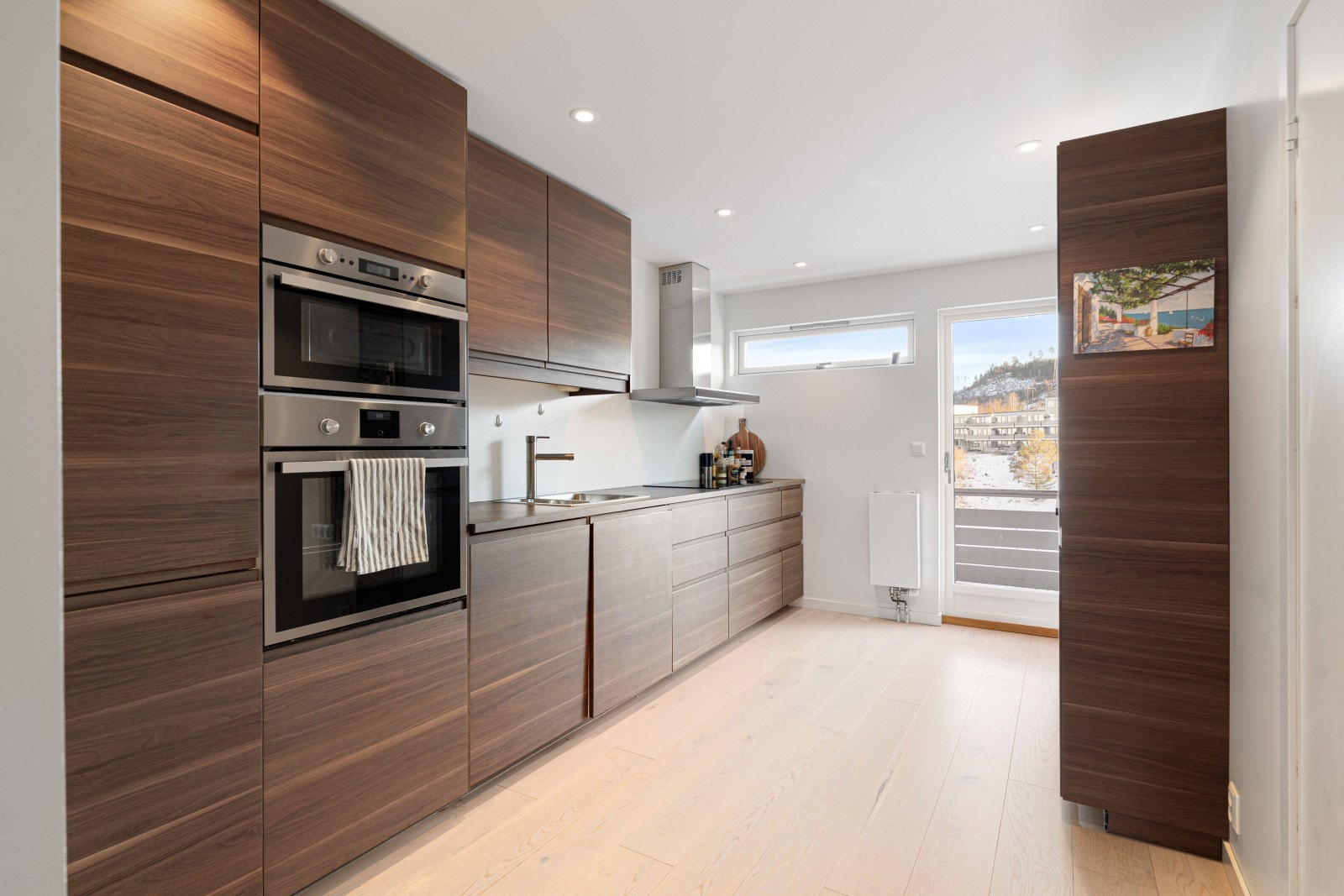 Stilrent kjøkken med mye skap-og benkeplass. Galleribilde