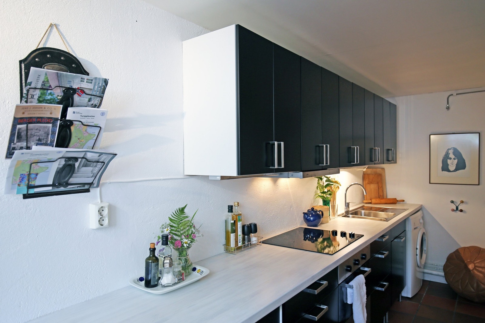 Tidløst kjøkken fra 2010 med benkeplate med høytrykkslaminert overflate og kum i rustfritt stål. Opplegg for vaskemaskin. Galleribilde