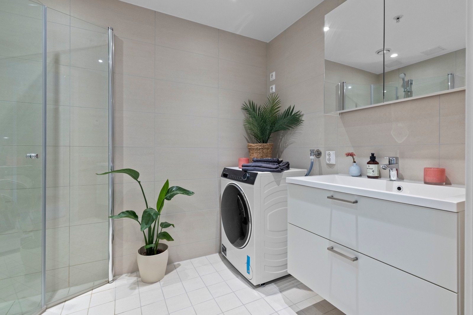 Leiligheten har et lekkert og romslig baderom med heldekkende servant på benkeseksjon og glatte fronter. Galleribilde