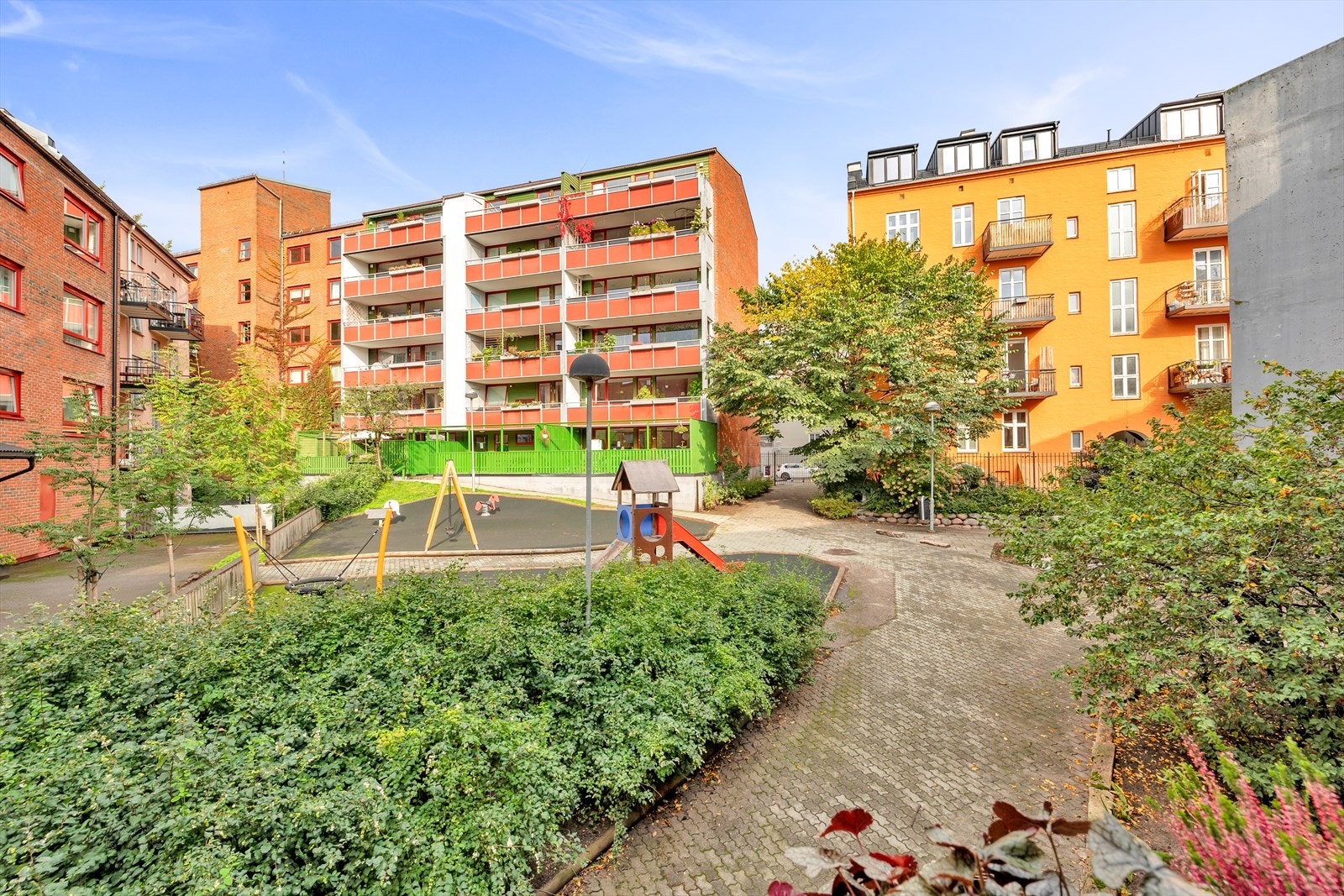 Bakgården er lukket og er et fint tilskudd til balkongen om man skal ha større selskap. Her er det sittegrupper og lekeplass til fri benyttelse. Galleribilde