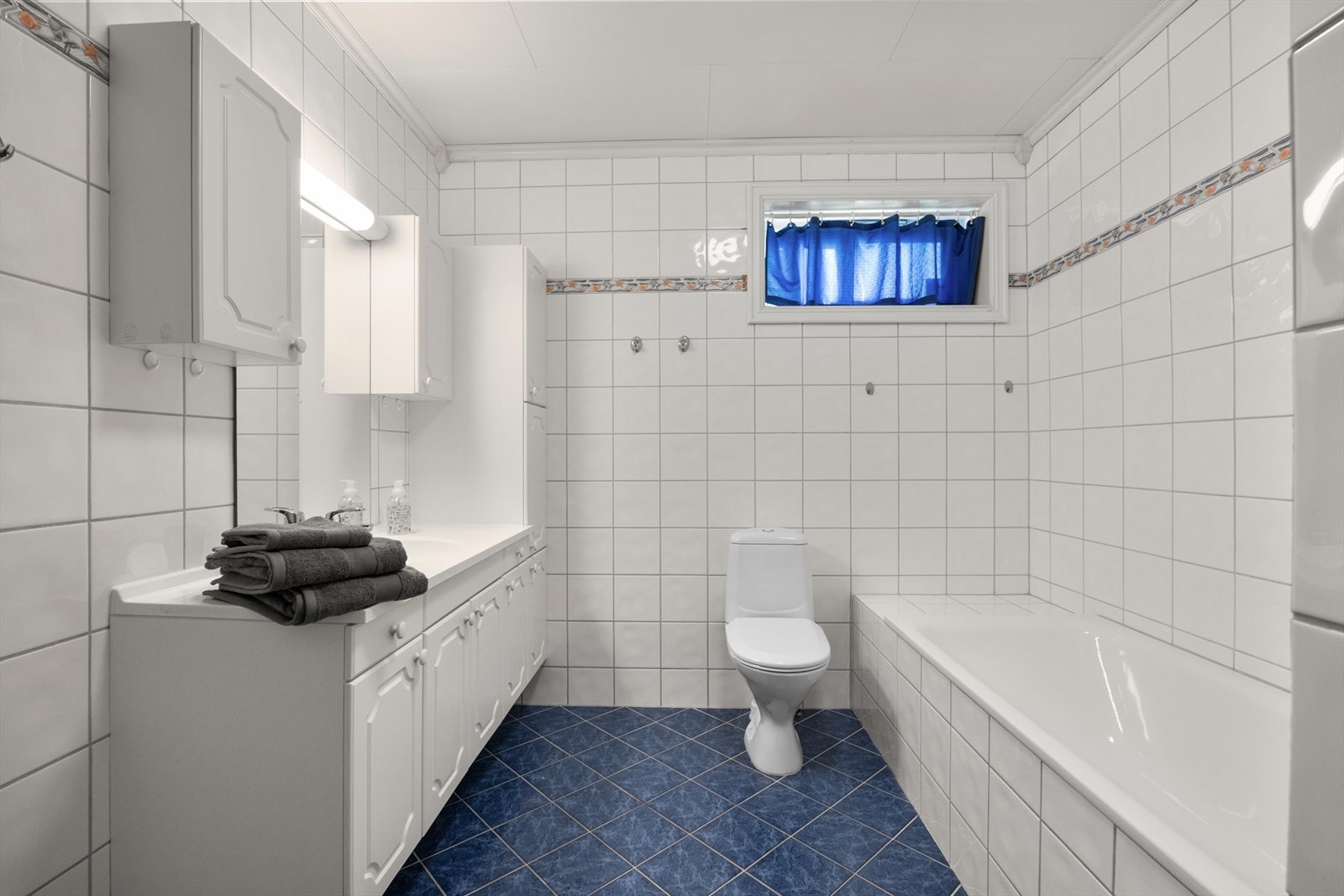 Stort, flislagt baderom med behagelig gulvvarme i boligens underetasje. Klosettet er montert nytt i 2024. Galleribilde