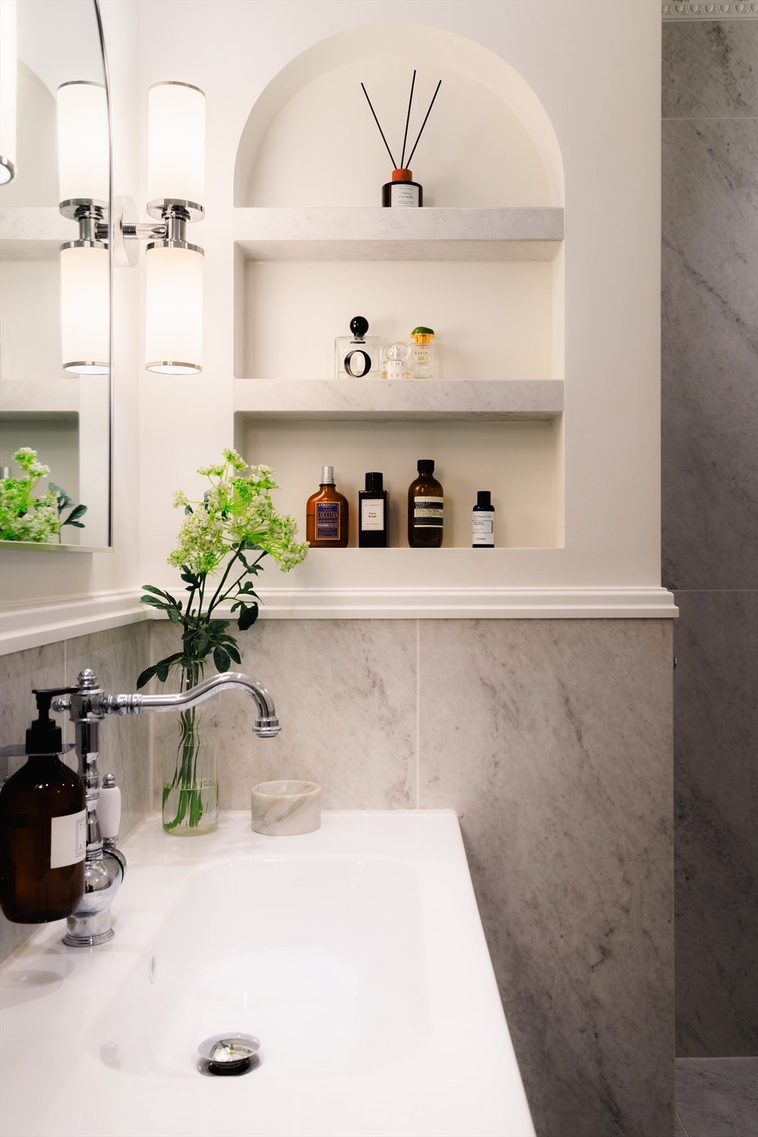 adet er innredet med badekar, stilren servant med skuffer for praktisk oppbevaring, vegghengt speil samt innebygde nisjer til oppbevaring og dekor. Galleribilde