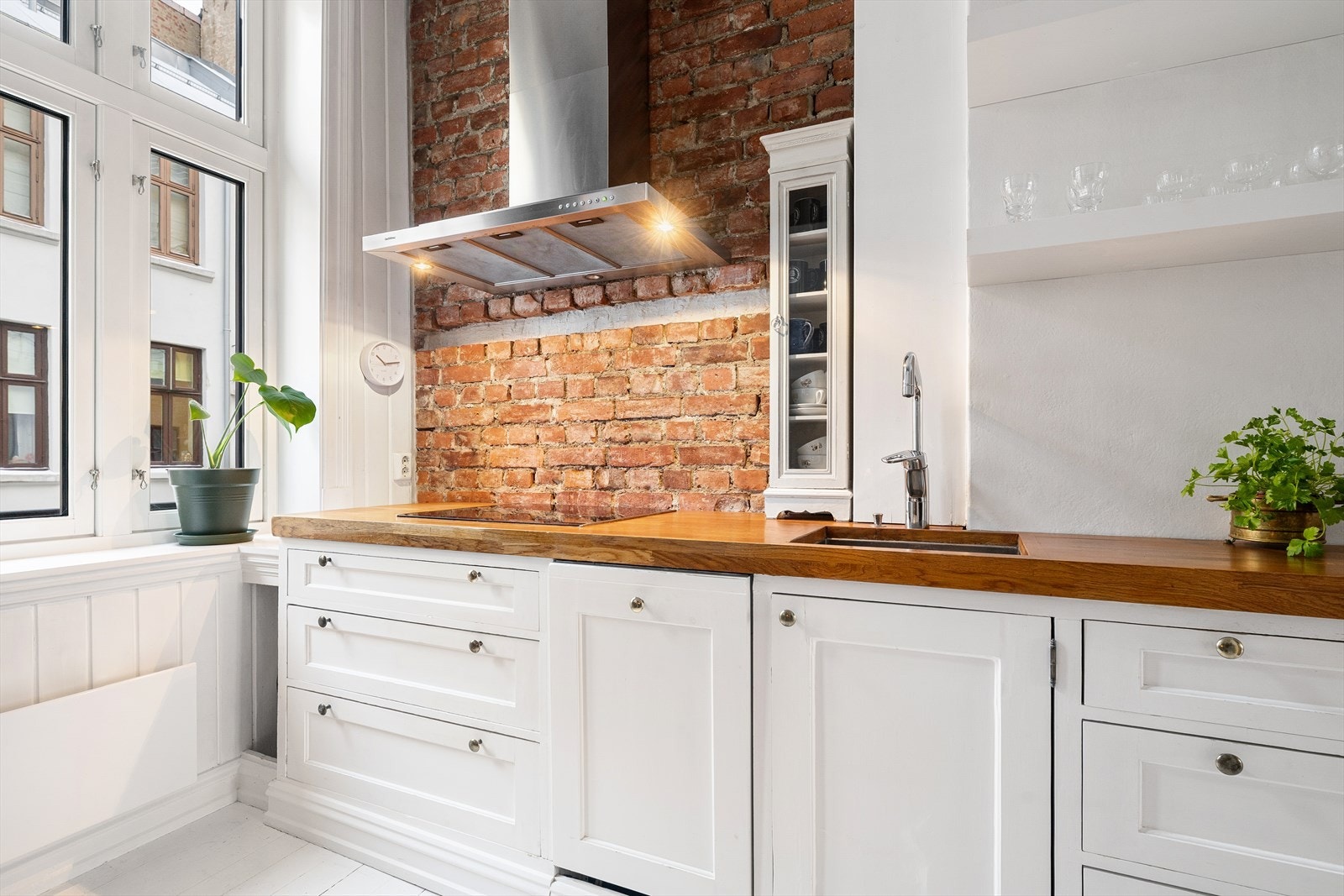 Eldre plassbygget kjøkkeninnredning med profilerte fronter og stort vindu som gir godt med naturlig lys til rommet. Galleribilde