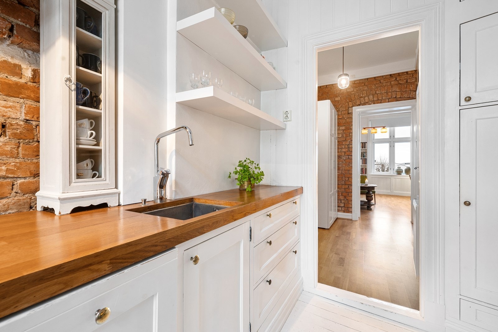 Heltre benkeplate med underlimt kum i rustfritt stål. Kullfilterventilator, induksjonstopp, stekeovn, oppvaskmaskin og kjøl er integrert i
innredningen. Galleribilde