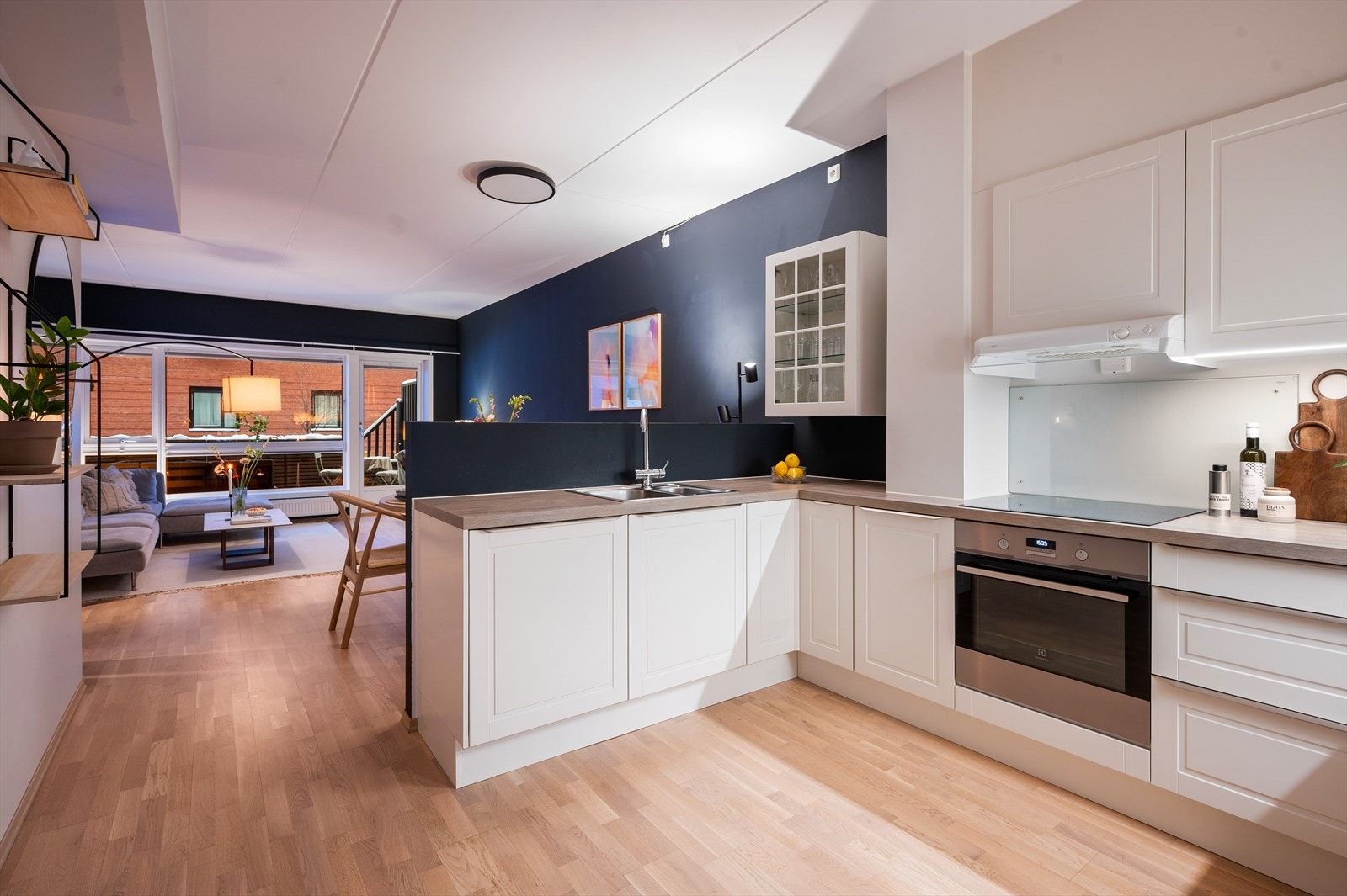 Innredningen er moderne med hvite, glatte fronter og laminat benkeplate med nedfelt vask. Galleribilde