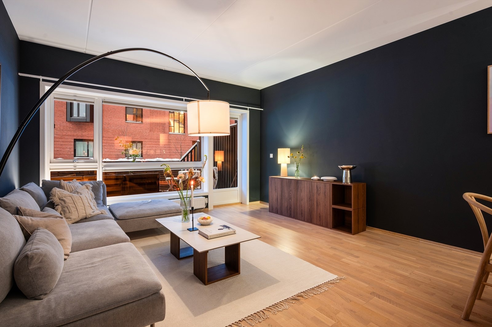 Romslig og innbydende stue med store gulv-til-tak-vinduer som slipper inn rikelig med naturlig lys. Galleribilde