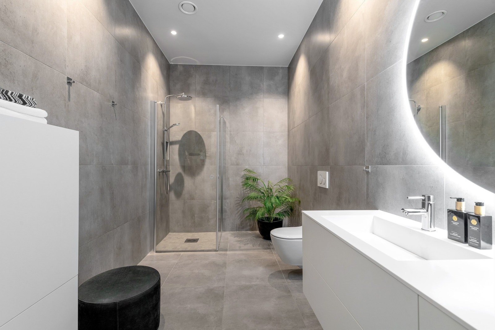 Badet har dusjhjørne med glassvegger og vegghengt dusjarmatur med hånddusj og regndusj. Vegghengt toalett. Galleribilde