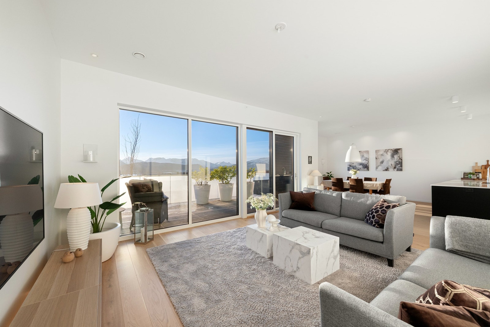 Stuen har stor skyvedør ut til balkong med glassrekkverk og nydelig utsikt Galleribilde