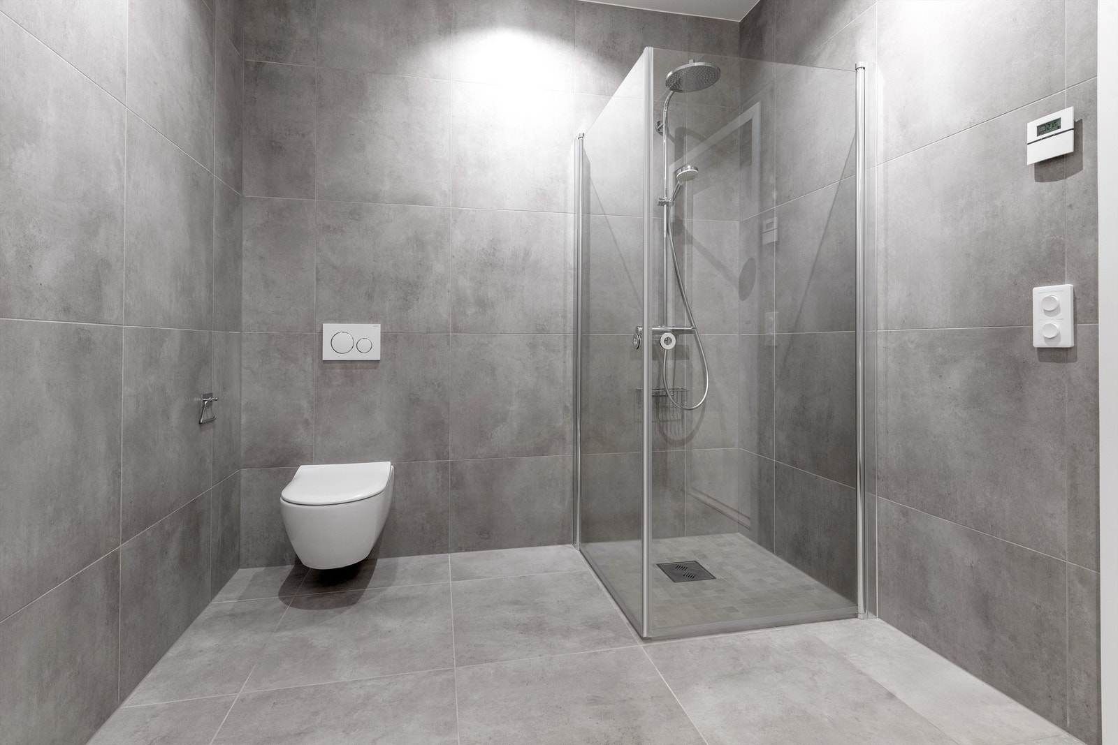 Bad i underetasjen med dusjhjørne med hånddusj og regndusj. Vegghengt toalett Galleribilde