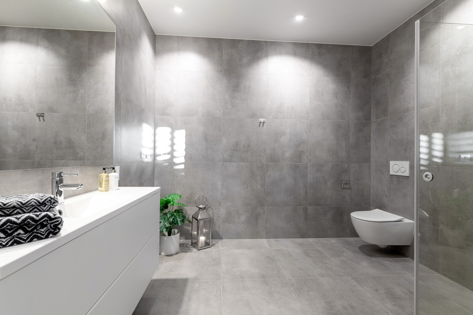 Romslig bad i underetasjen med servantinnredning, speilskap, dusjhjørne og vegghengt toalett. Det er også mulighet for opplegg av vaskemaskin her Galleribilde