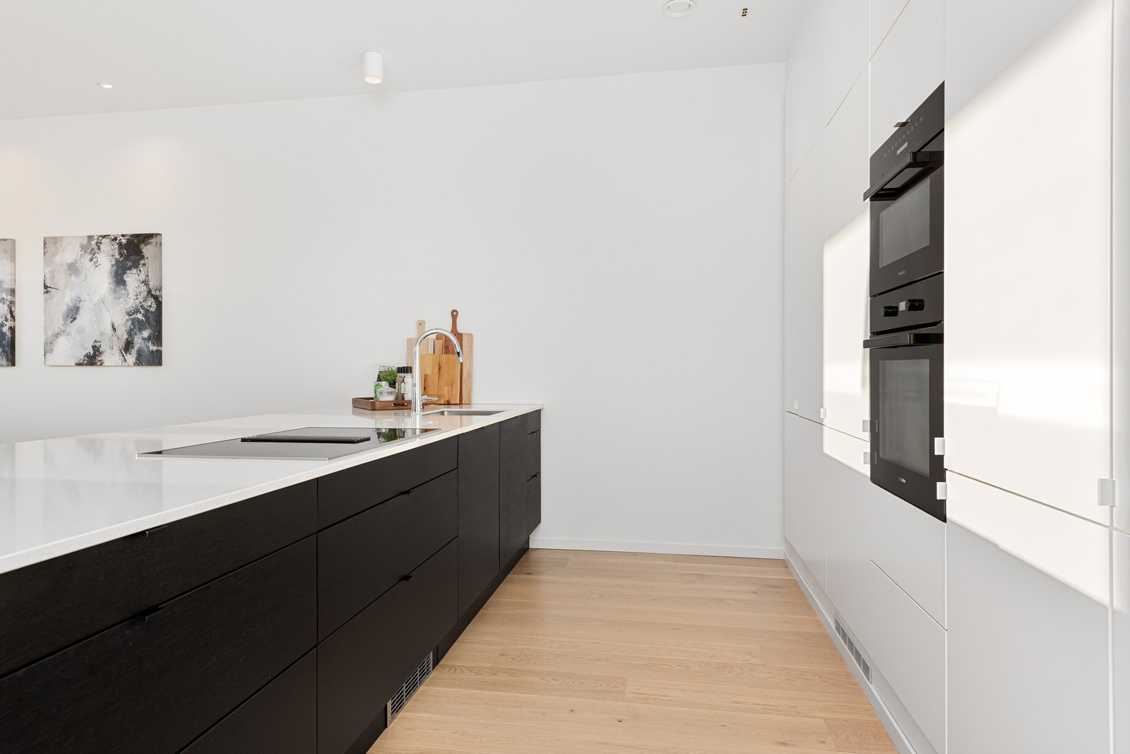 Stor og romslig kjøkkenøy mot stue/spisestue. Kjøkkenøyen har skap på begge sider og gode oppbevaringsmuligheter Galleribilde