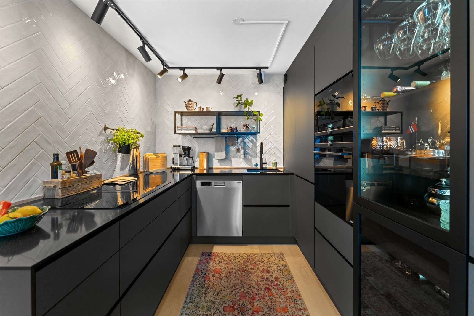 Selve kjøkkenet er stilrent og moderne- Innredningen ble levert av Kvik, med sorte, glatte fronter, dype skuffer, praktiske høyskap, nedfelt oppvaskkum og mørk benkeplate av kompositt. Galleribilde