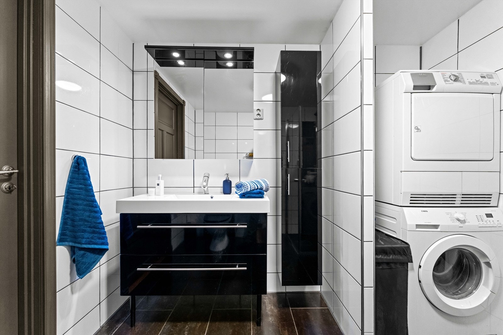 Opplegg for vaskemaskin er etablert i egen nisje, og badet har toalett, dusjhjørne og varmekabler. Dusjsonen er utstyrt med regnfallsdusj, mosaikkfliser og innfellbare glassdører. Galleribilde