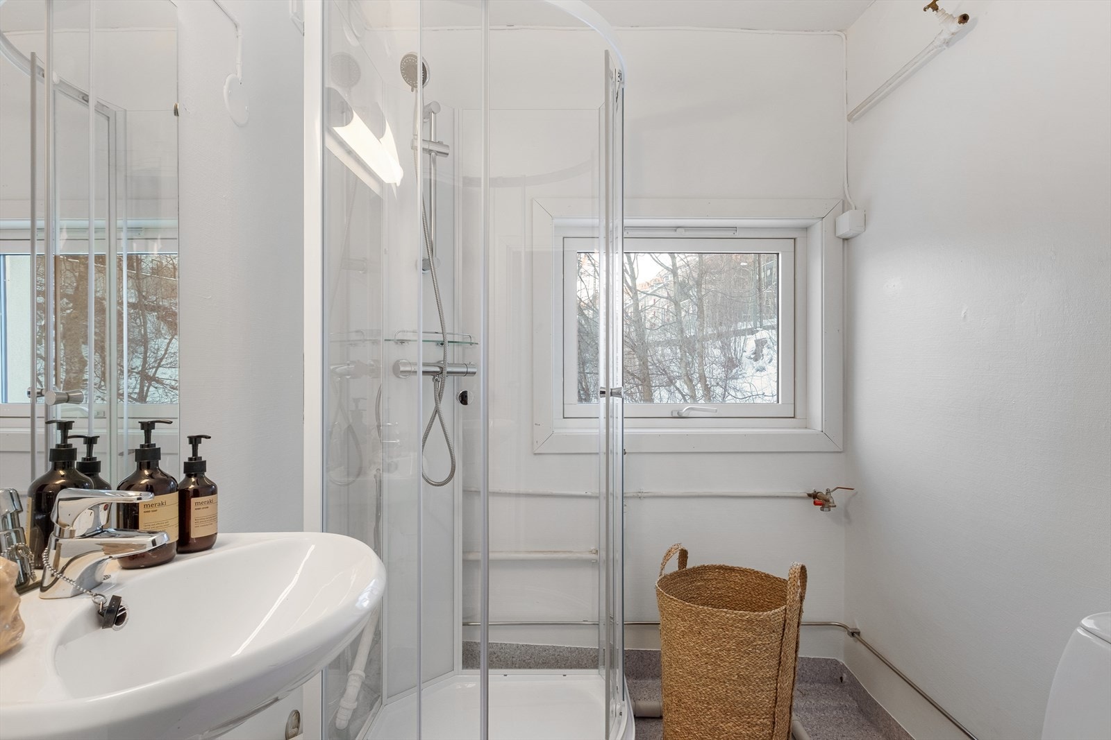 Bad med dusjkabinett, servant og speil. Opplegg for vaskemaskin. Galleribilde