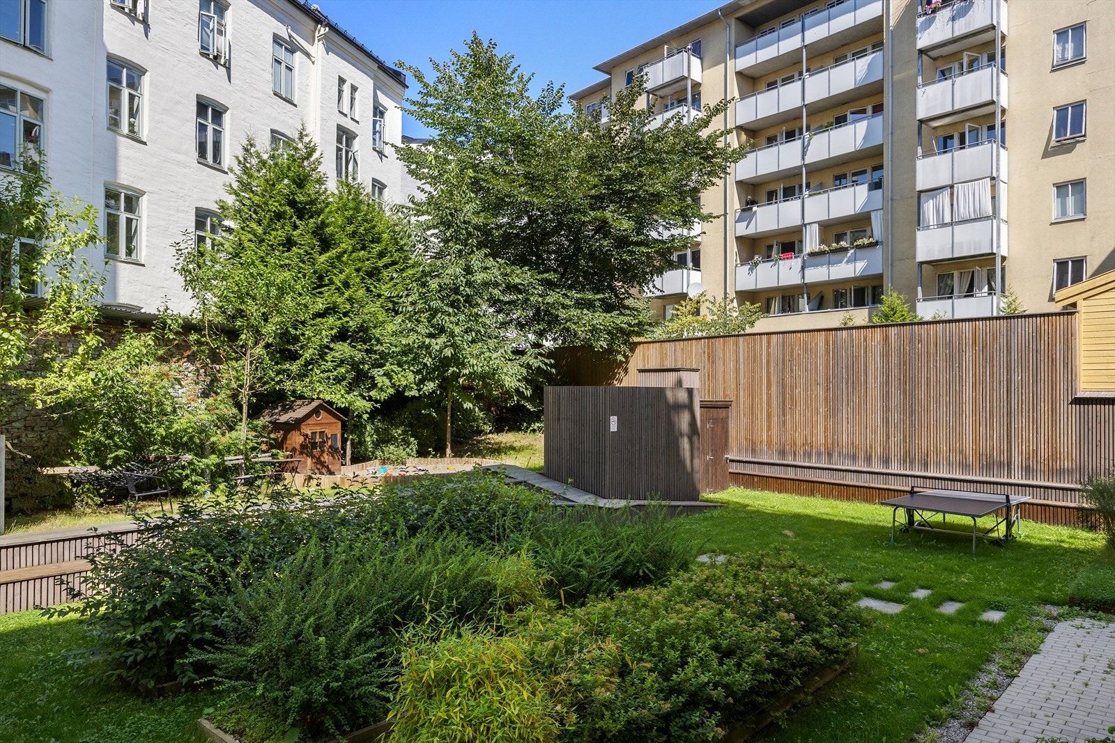 Hyggelig bakgård med sandkasse for de minste, og blandt annet ping-pong bord og hammock. Galleribilde