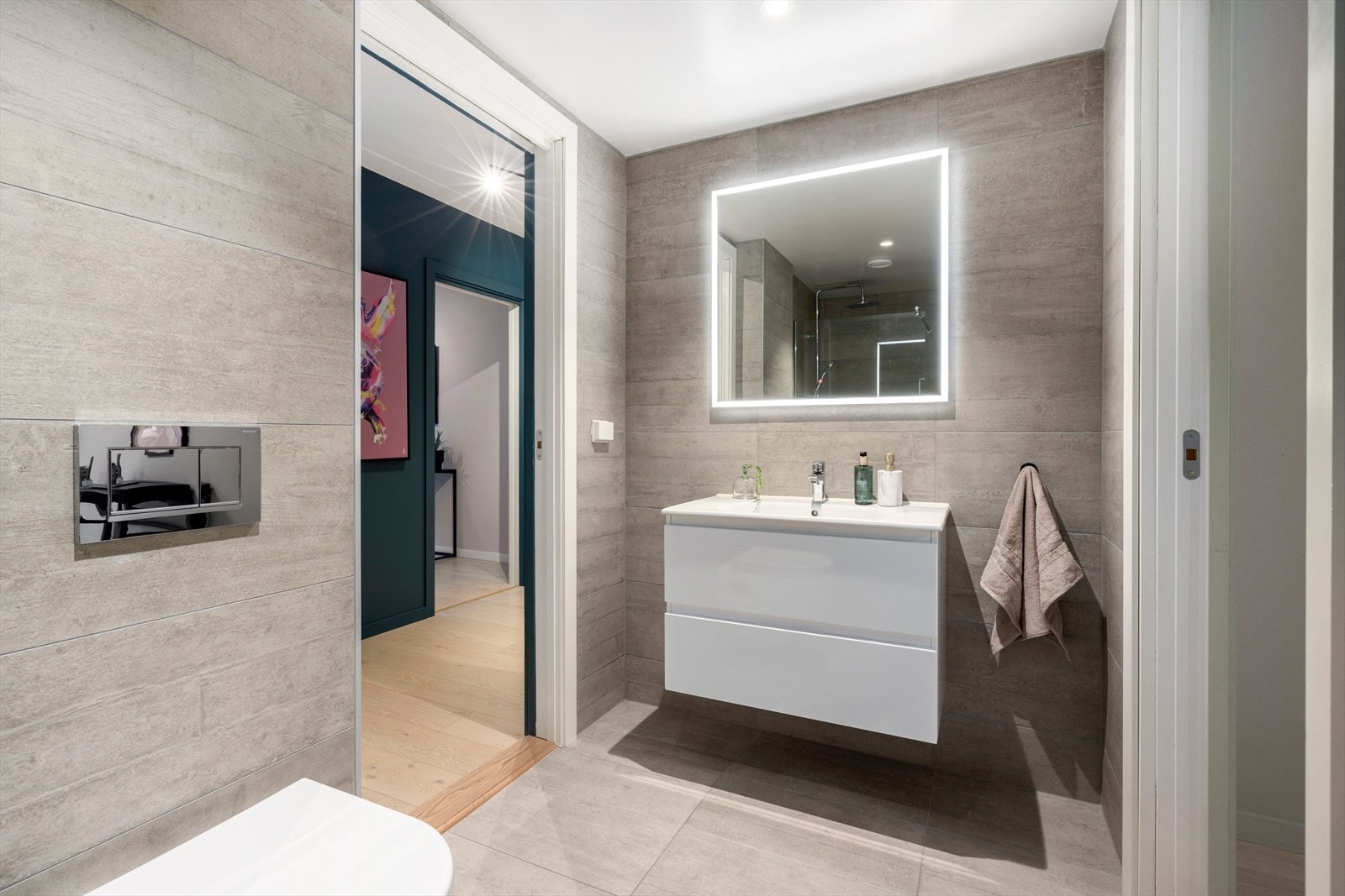 Toalettet er vegghengt og man har speil med belysning over servant, downlights i tak og elektrisk gulvvarme. Galleribilde