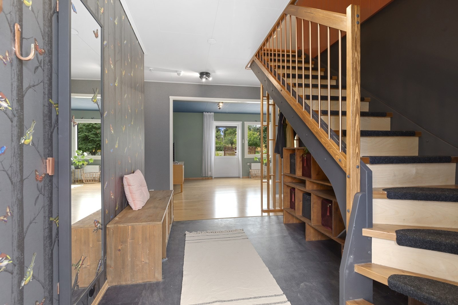 Det er adkomst til boligen fra bakkeplan, og inn i første etasje. Velkommen inn - her ønskes du velkommen inn i lys entrè med plass til å henge fra deg ytterklær. Galleribilde