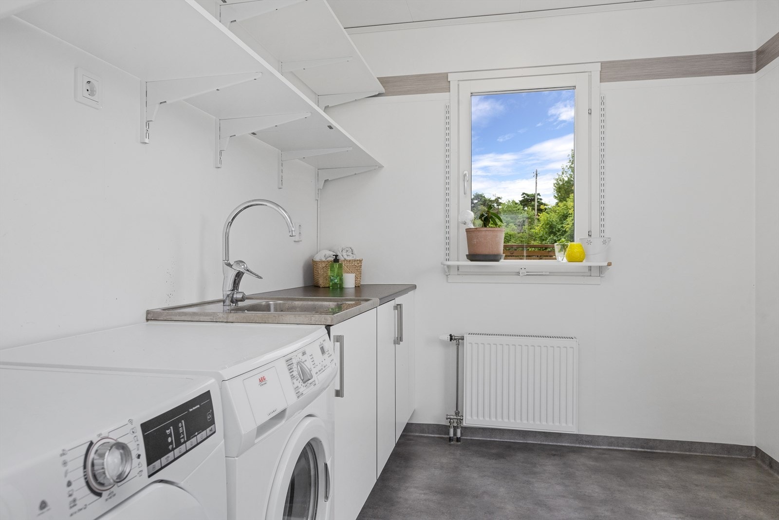 Boligen har eget vaskerom - et praktisk rom!
Vaskerommet er med vinylbelegg på gulv og malte slette plater samt vinylbelegg på vegger. Videre er rommet utstyrt med innredning med underskap, utslagskum, og det er opplegg for vaskemaskin og tørketrommel. Galleribilde