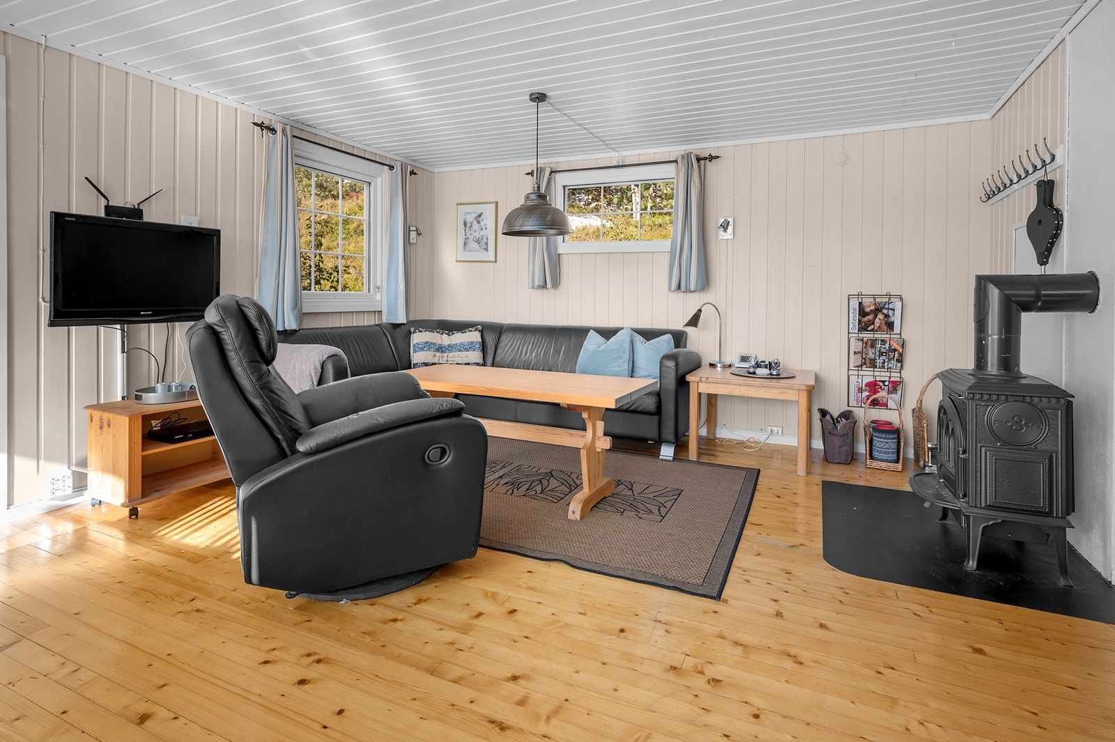 Vedfyrt ovn i stue som varmer godt om det fyres. Galleribilde