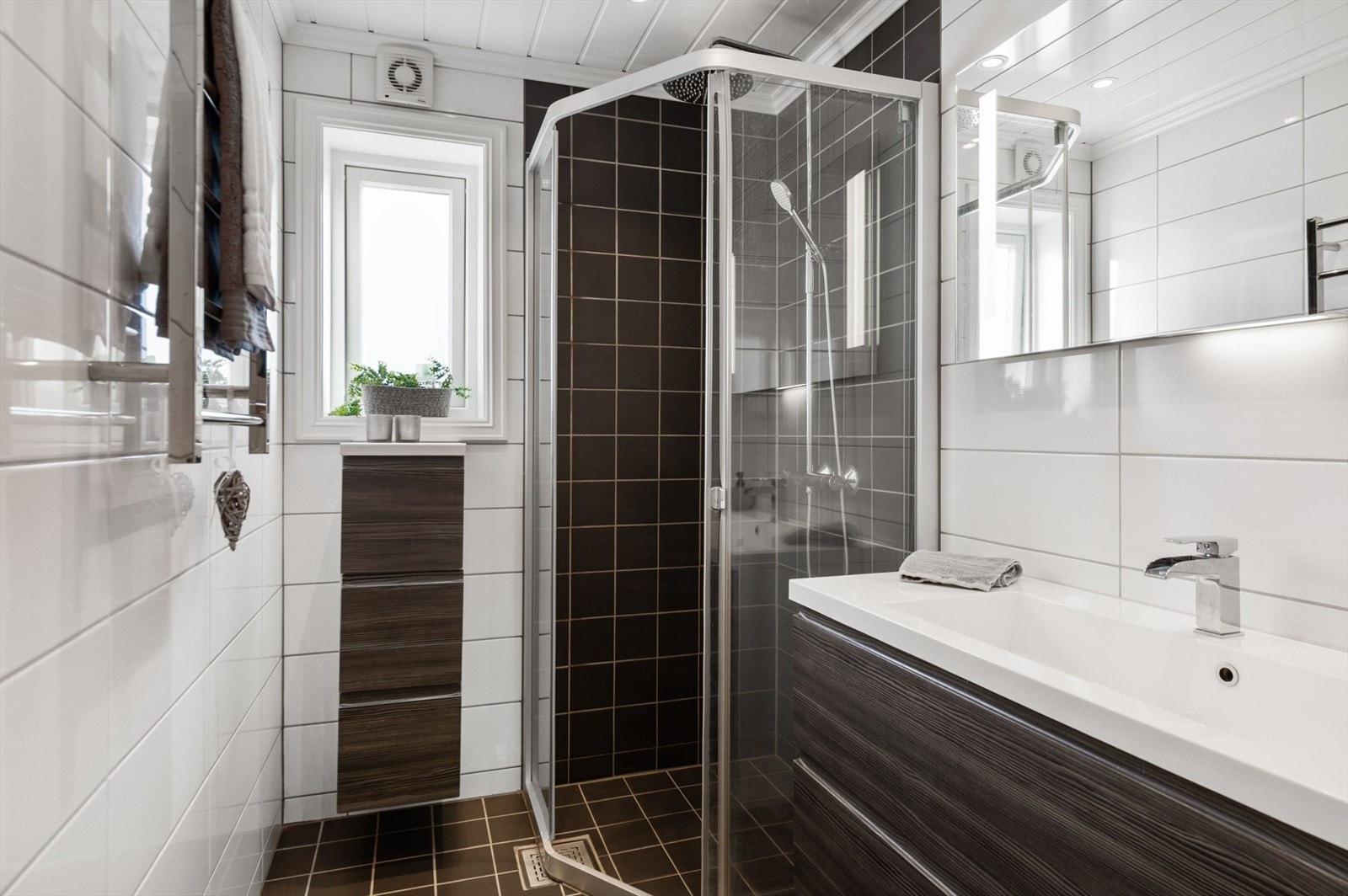 Badet har mørk innredning og dusjkabinett. Galleribilde