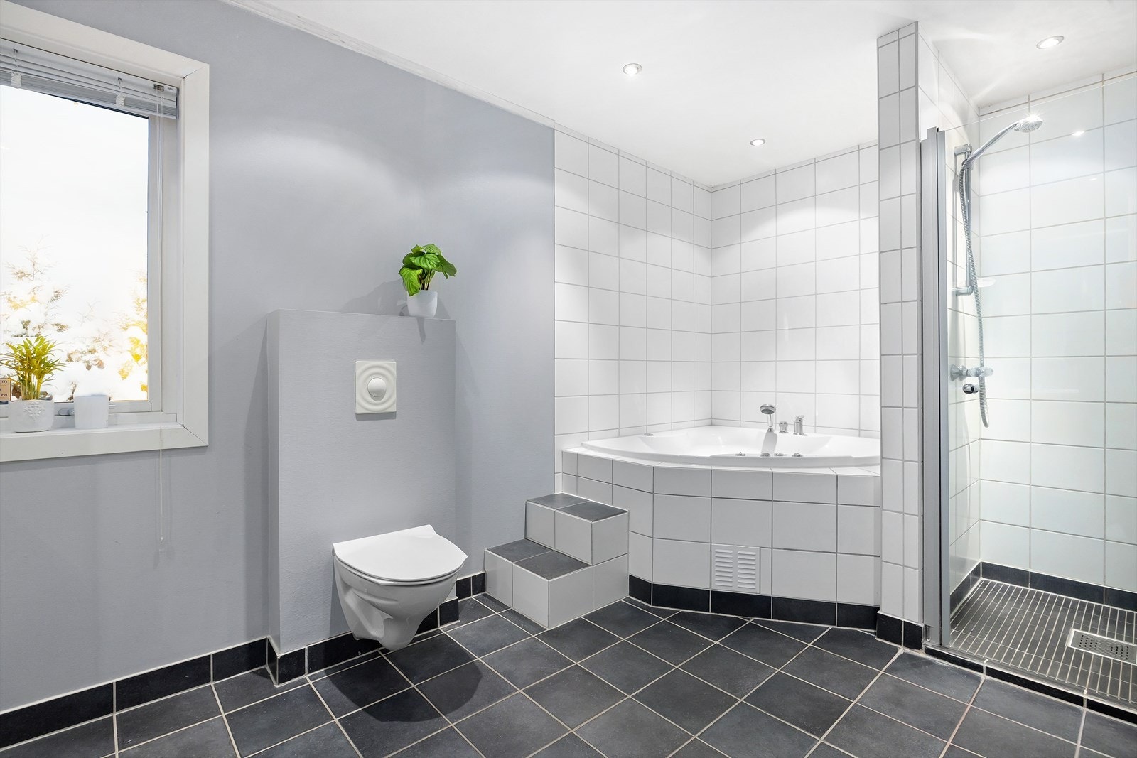 Stort bad med flislagt gulv og varmekabler. Galleribilde