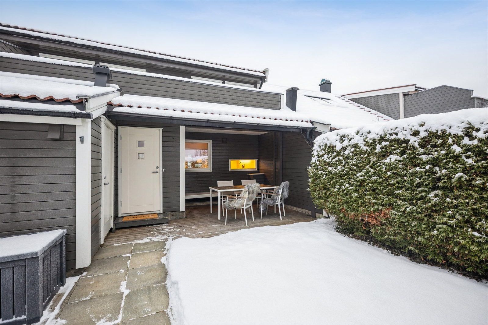 Inngangsparti med vest-vendt overbygget platting med god plass til en hyggelig sittegruppe. Foto: Per O. Skjellnan v/Efkt Galleribilde