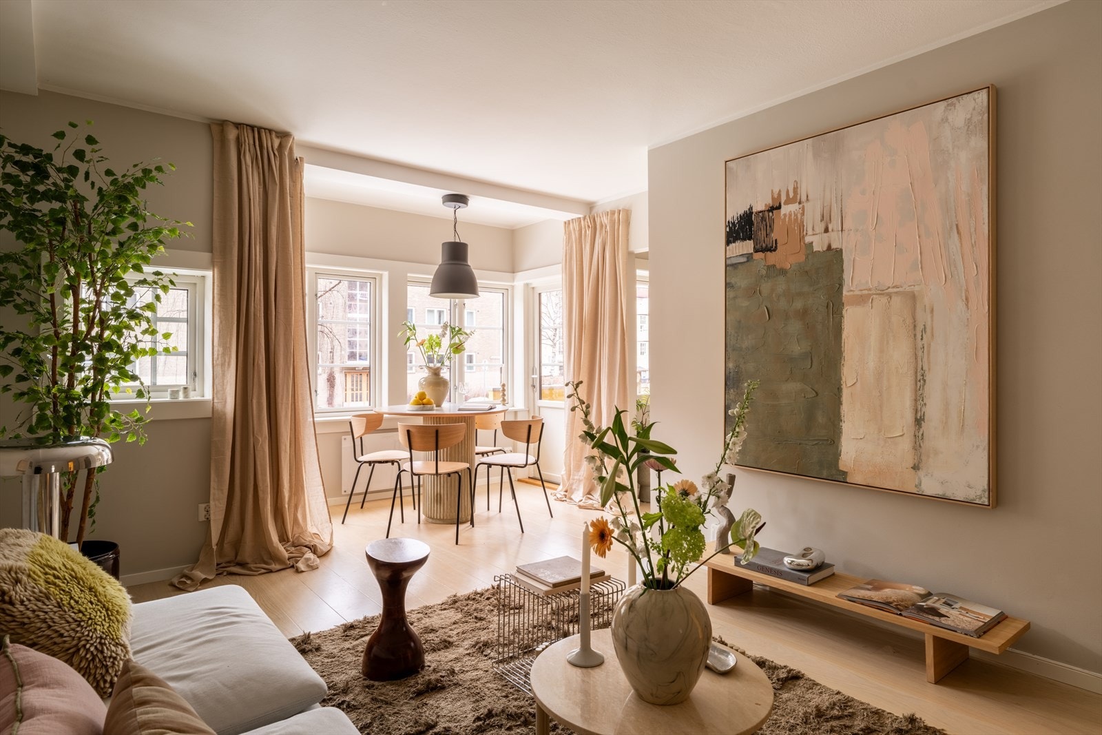 Åpen løsning mellom stue og kjøkken, men med vegg i mellom som lager en fin soneinndeling og naturlige soner for møblering. Galleribilde