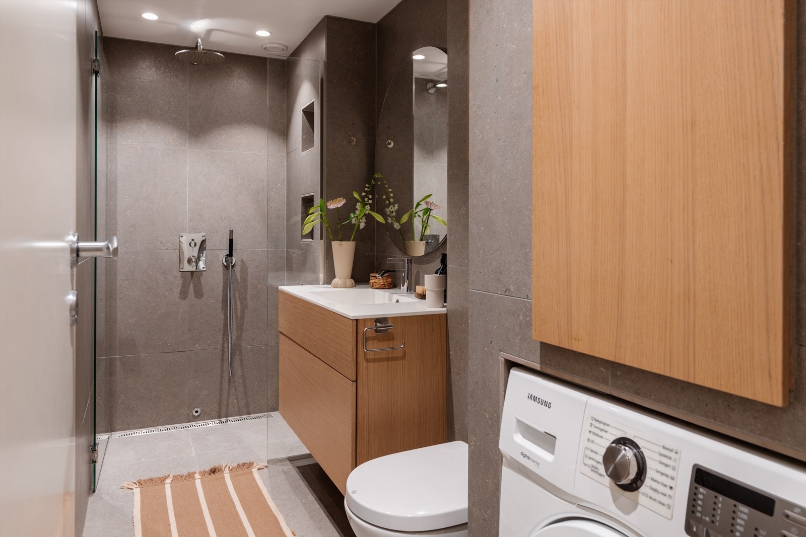 Her er det vegghengt toalett med innebygget sisterne og opplegg for vaskemaskin. Galleribilde