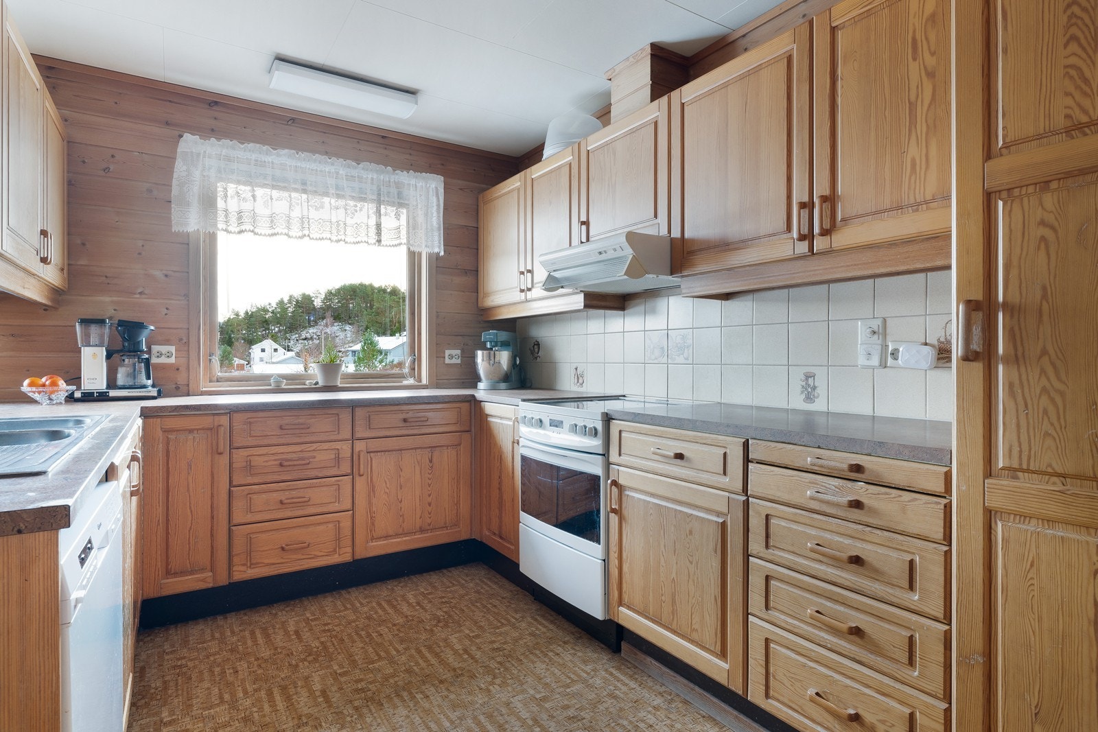 Innredningen har profilerte fronter og fliser på vegg over benk. Galleribilde