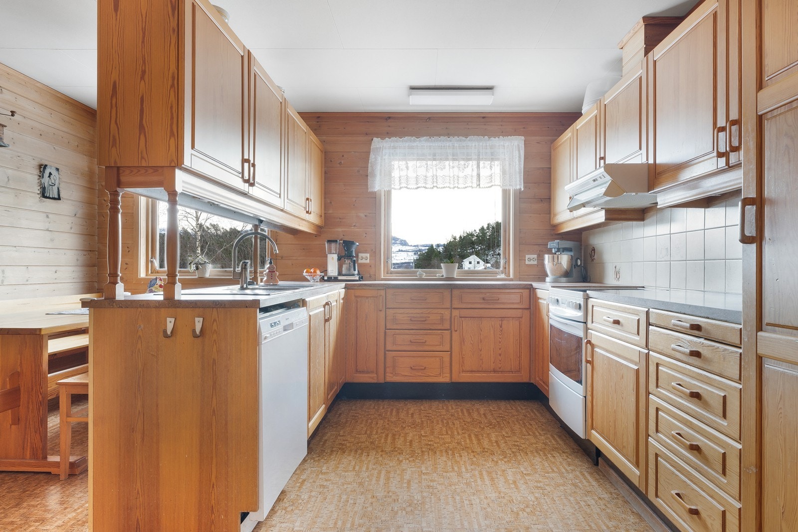 Kjøkkeninnredning i heltre furu med rikelig av skap- og benkeplass. Galleribilde