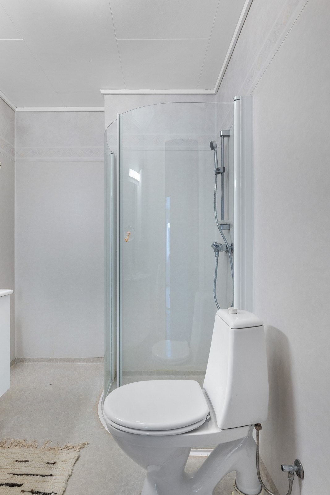 Bad 1 er innredet med dusj, toalett og vask med skap. Galleribilde