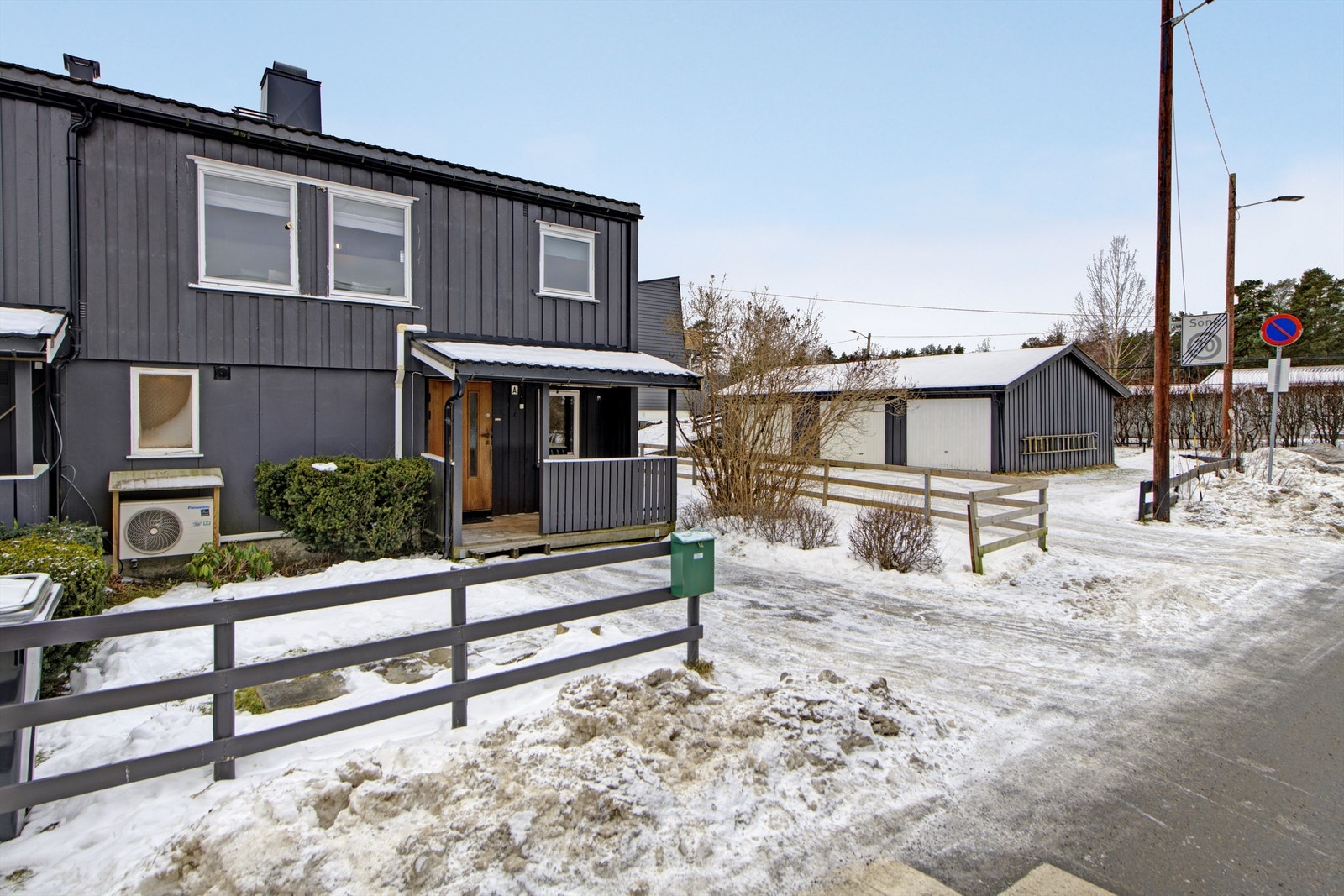 Fasade ved inngangsparti - overbygget inngangsparti - plass til parkering på egen gårdsplass og i felles garasjerekken (i garasjerekken som sees til høyre i bildet) Galleribilde