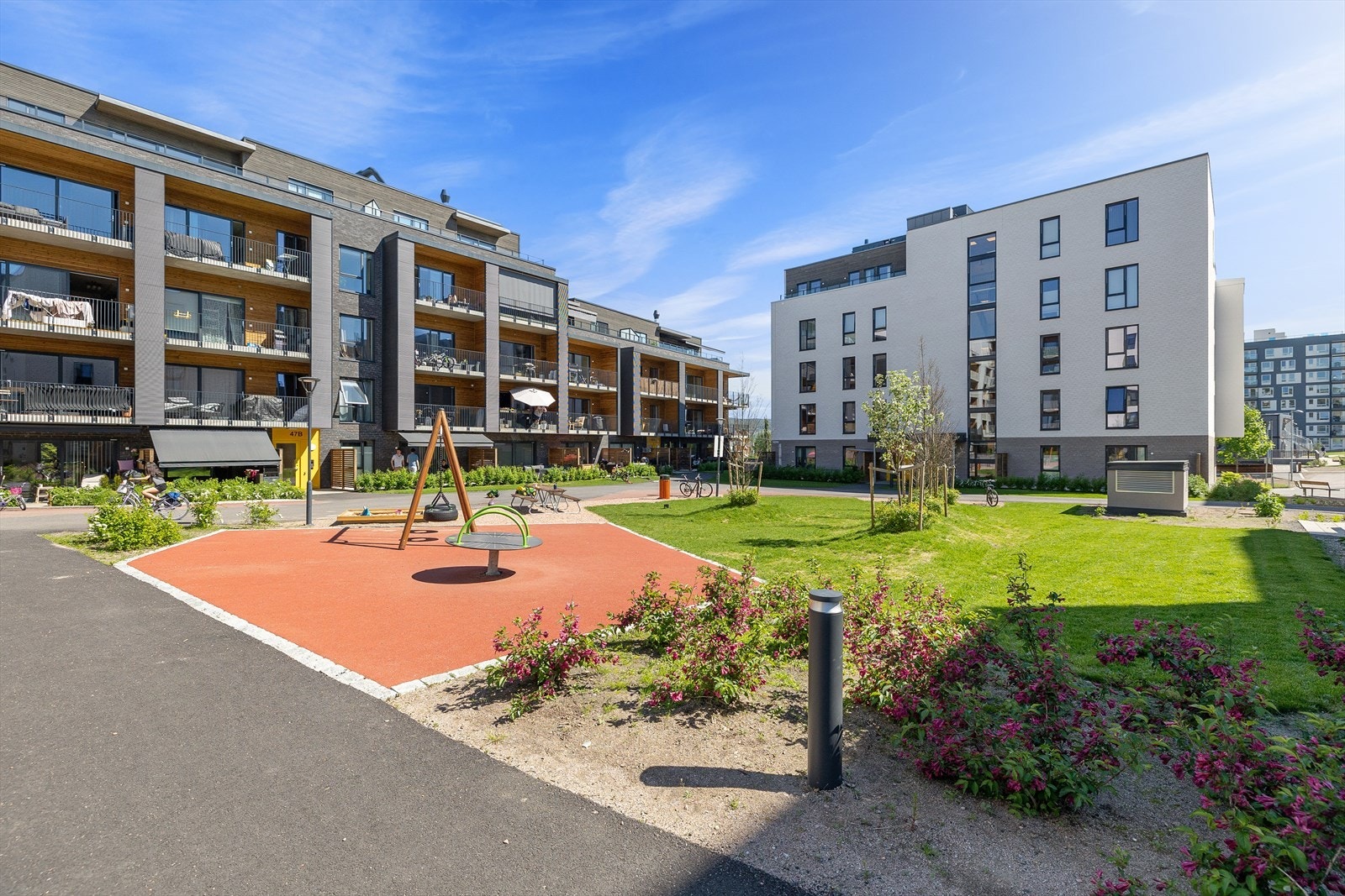Bilfritt og barnevennlig område med lekeplasser og sittegrupper. Galleribilde