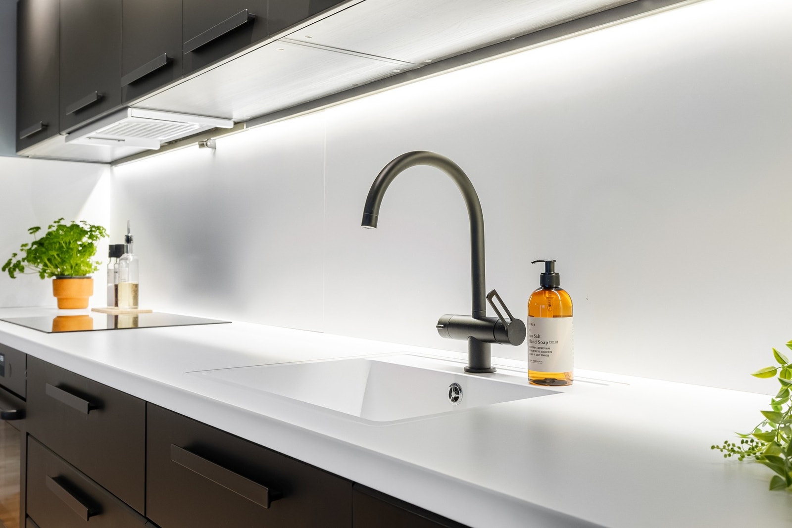 Kjøkkenet er innredet med slette fronter, overskap med benkebelysning og plater på vegg som gir et moderne og helhetlig uttrykk. Galleribilde