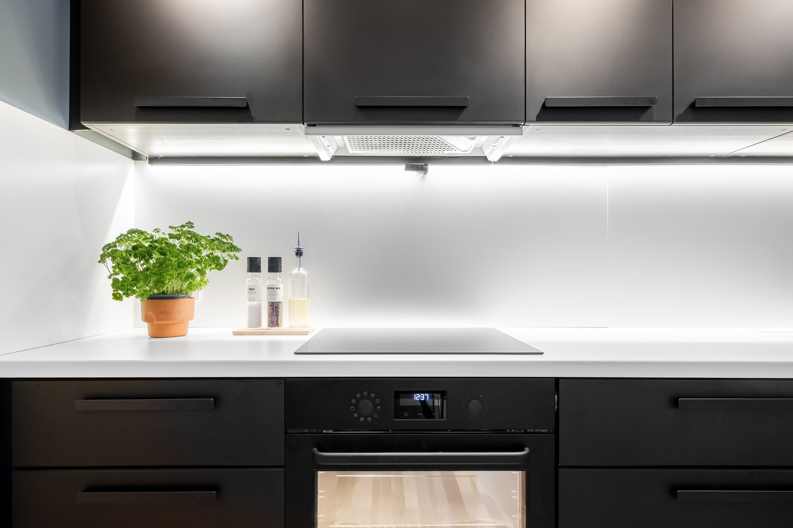 Hvit laminat benkeplate med planlimt vask og ettgreps armatur i sort. Galleribilde